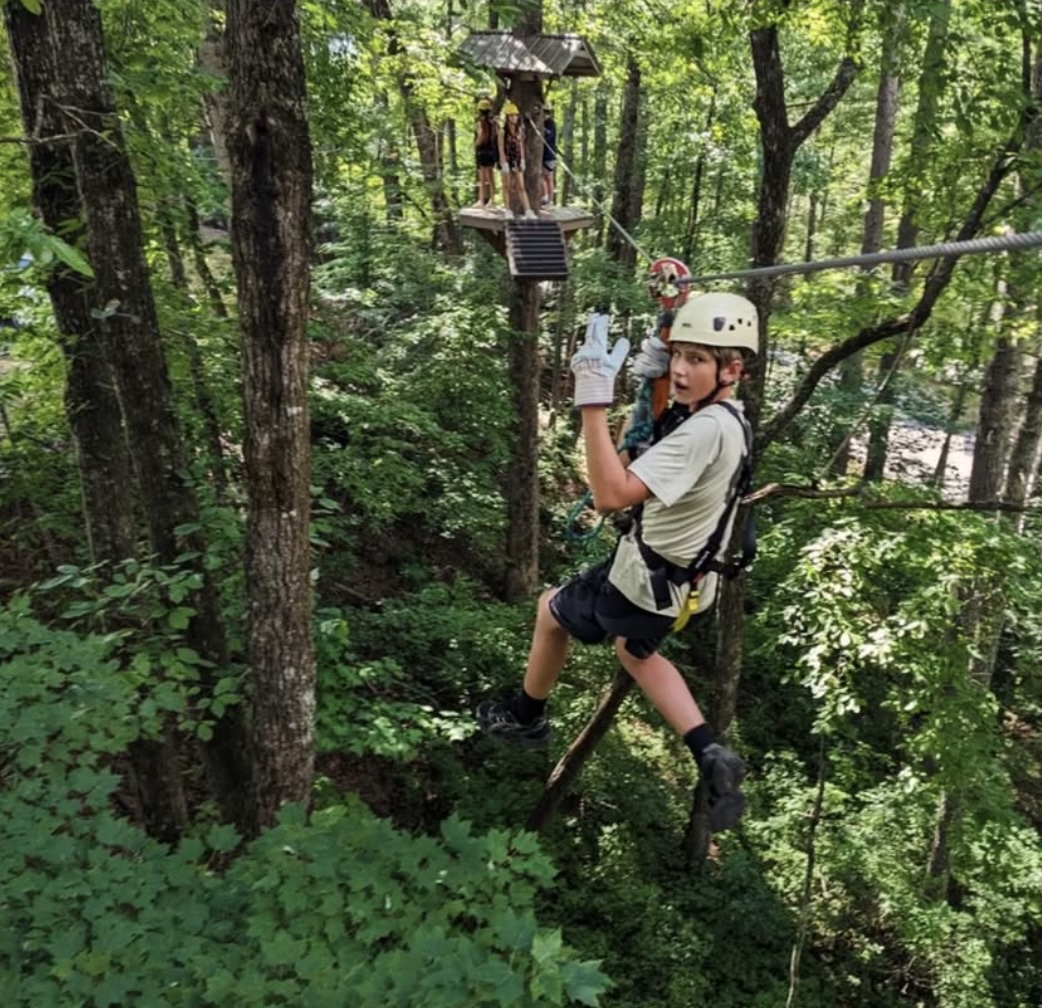 Scout on a zipline during a troop adventure