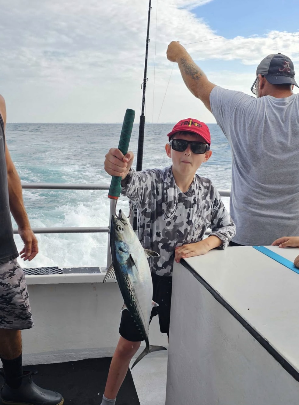 Scout holding a fish during a troop fishing trip