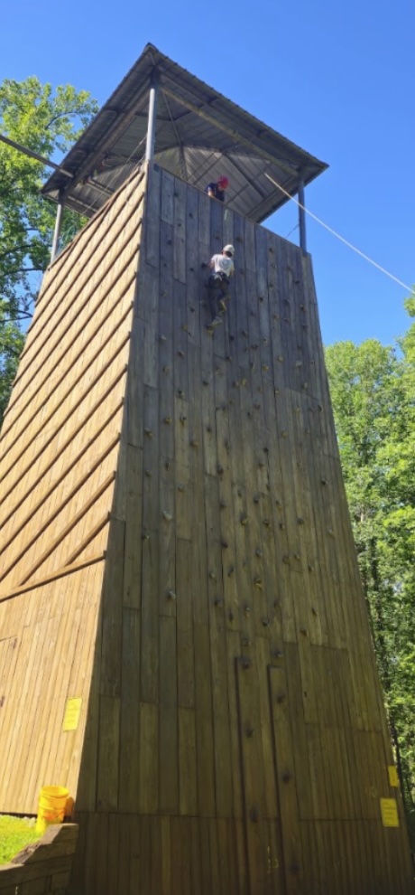 Scout climbing a tower during an outdoor adventure